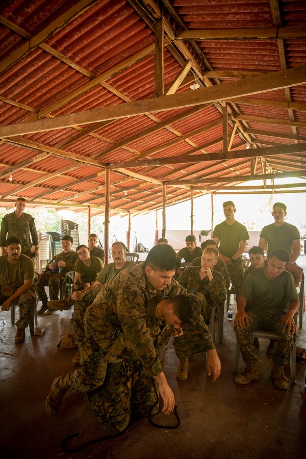 U.S. Marines with 2d Battalion, 2d Marine Regiment, 2d Marine Division, demonstrate a Brazilian tactic for carrying casualties during a first aid class as part of a bilateral jungle training event in Manaus, Brazil, Sept. 26, 2022. U.S. partnerships in the U.S. Southern Command area of responsibly are forged by shared challenges and common objectives. Bilateral training events such as jungle training develops and sustains relationships that improve the capacity of U.S. and partner nation maritime forces to achieve common desired effects. This exchange of knowledge between critical regional partners fosters interoperability, friendly relationships, and mutual cooperation. (U.S. Marine Corps photo by Sgt. Camila Melendez)