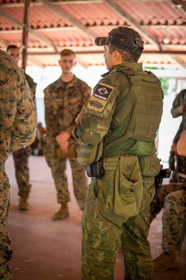 A Brazilian Marine debriefs U.S. Marines and Sailors with 2d Battalion, 2d Marine Regiment, 2d Marine Division, after a raid scenario as part of a bilateral jungle training event in Manaus, Brazil, Sept. 27, 2022. Throughout the training event, U.S. Marines applied tactics and knowledge given to them by the Brazilian Marines, who regularly operate in the Amazon jungle. The U.S. integrates with partners by building trust, strengthening interoperability through training and equipment, and reinforcing a shared vision of prosperity and hemispheric security. (U.S. Marine Corps photo by Sgt. Camila Melendez)