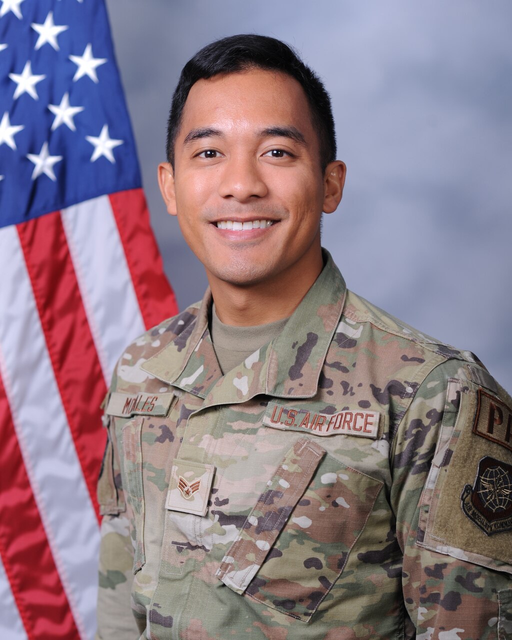 A male service member wearing a uniform poses for a photo.