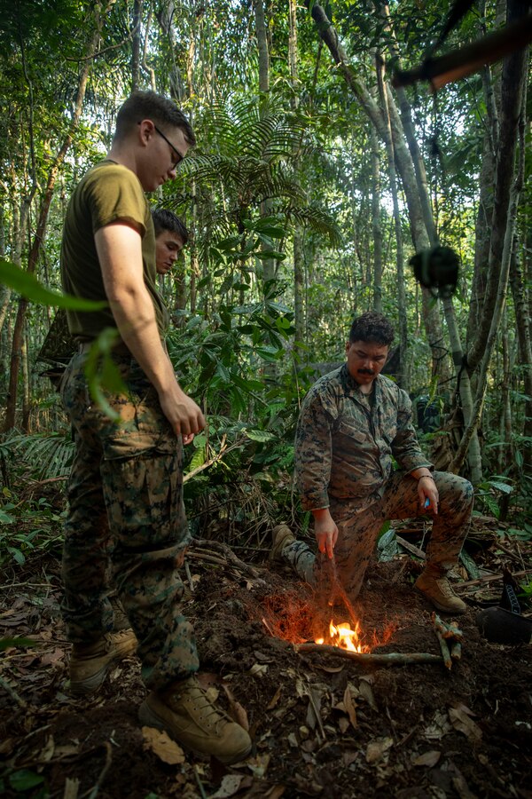 U.S. Marines and Sailors with 2d Battalion, 2d Marine Regiment, 2d Marine Division, make a fire as part of a bilateral jungle training event in Manaus, Brazil, Sept. 28, 2022. Throughout the training event, U.S. Marines applied tactics and knowledge given to them by the Brazilian Marines, who regularly operate in the Amazon jungle. Exercises and bilateral training events like Brazil’s jungle training provide the opportunity for U.S. Marines to train alongside partner forces in unique and complex environments to develop and improve readiness. Training in austere locations provide the opportunities to develop skills that are critical to force readiness and employment in the future operating environment. (U.S. Marine Corps photo by Sgt. Camila Melendez)