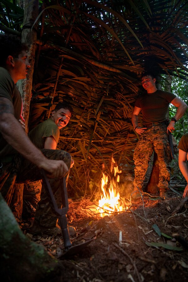 U.S. Marines and Sailors with 2d Battalion, 2d Marine Regiment, 2d Marine Division, gather around a fire during a bilateral jungle training event in Manaus, Brazil, Sept. 28, 2022. Throughout the training event, U.S. Marines applied tactics and knowledge given to them by the Brazilian Marines, who regularly operate in the Amazon jungle. Exercises and bilateral training events like Brazil’s jungle training provide the opportunity for U.S. Marines to train alongside partner forces in unique and complex environments to develop and improve readiness. Training in austere locations provide the opportunities to develop skills that are critical to force readiness and employment in the future operating environment. (U.S. Marine Corps photo by Sgt. Camila Melendez)