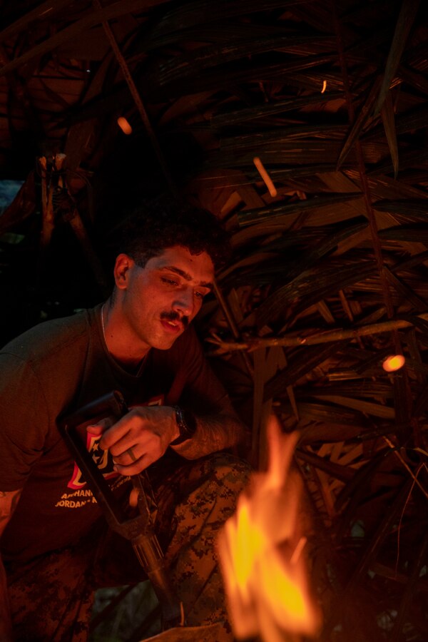 U.S. Marine Corps Sgt. Thomas Freckleton, an infantry Marine with 2d Battalion, 2d Marine Regiment, 2d Marine Division, watches a fire during a bilateral jungle training event in Manaus, Brazil, Sept. 28, 2022. Throughout the training event, U.S. Marines applied tactics and knowledge given to them by the Brazilian Marines, who regularly operate in the Amazon jungle. Exercises and bilateral training events like Brazil’s jungle training provide the opportunity for U.S. Marines to train alongside partner forces in unique and complex environments to develop and improve readiness. Training in austere locations provide the opportunities to develop skills that are critical to force readiness and employment in the future operating environment. (U.S. Marine Corps photo by Sgt. Camila Melendez)