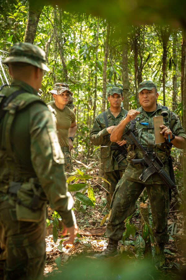 Brazilian Marines evaluate survival tactics demonstrated by Marines with 2d Battalion, 2d Marine Regiment, 2d Marine Division, as part of a bilateral jungle training event in Manaus, Brazil, Sept. 29, 2022. Throughout the training event, U.S. Marines applied tactics and knowledge given to them by the Brazilian Marines, who regularly operate in the Amazon jungle. Exercises and bilateral training events like Brazil’s jungle training provide the opportunity for U.S. Marines to train alongside partner forces in unique and complex environments to develop and improve readiness. Training in austere locations provide the opportunities to develop skills that are critical to force readiness and employment in the future operating environment. (U.S. Marine Corps photo by Sgt. Camila Melendez)