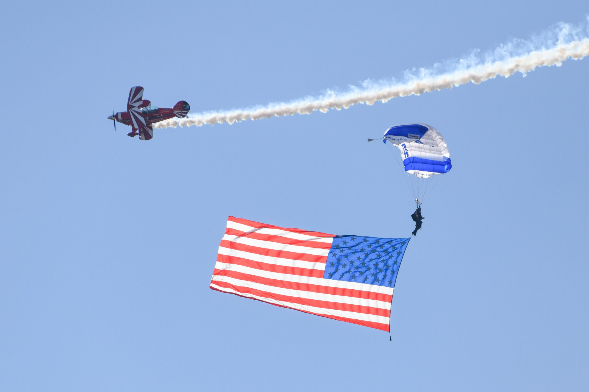 The U.S. Air Force Academy (USAFA) Wings of Blue and a Pitts S2B perform at the Red River Thunder airshow at Altus Air Force Base, Oklahoma, Oct. 1, 2022. The Wings of Blue consists of enlisted service members and cadets from the USAFA. (U.S. Air Force photo by Senior Airman Kayla Christenson)