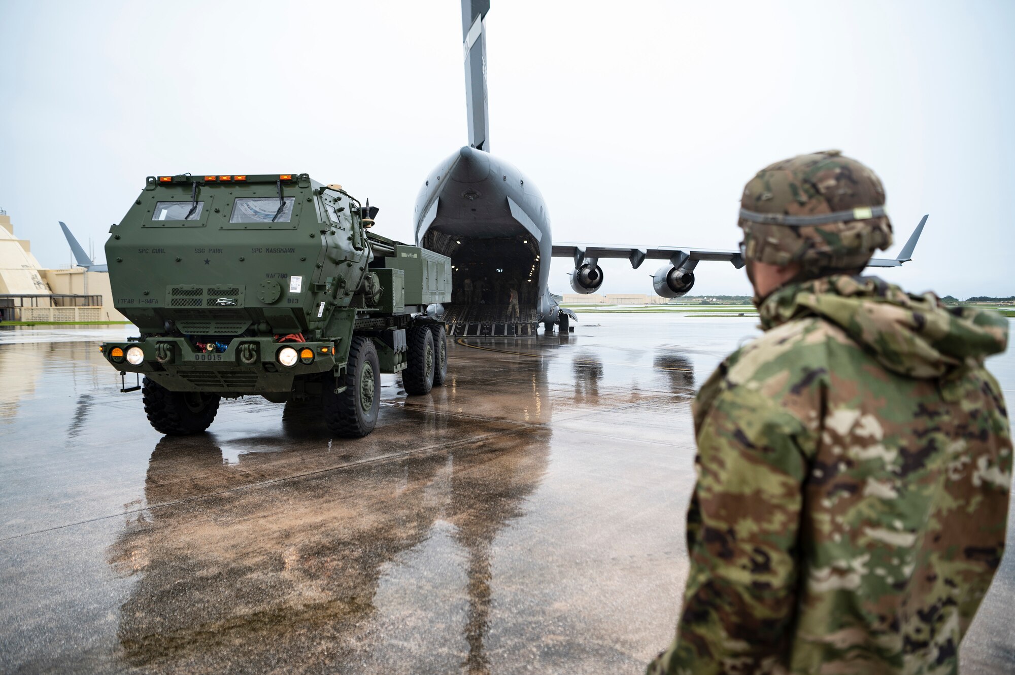 A man watches a military load onto a plane