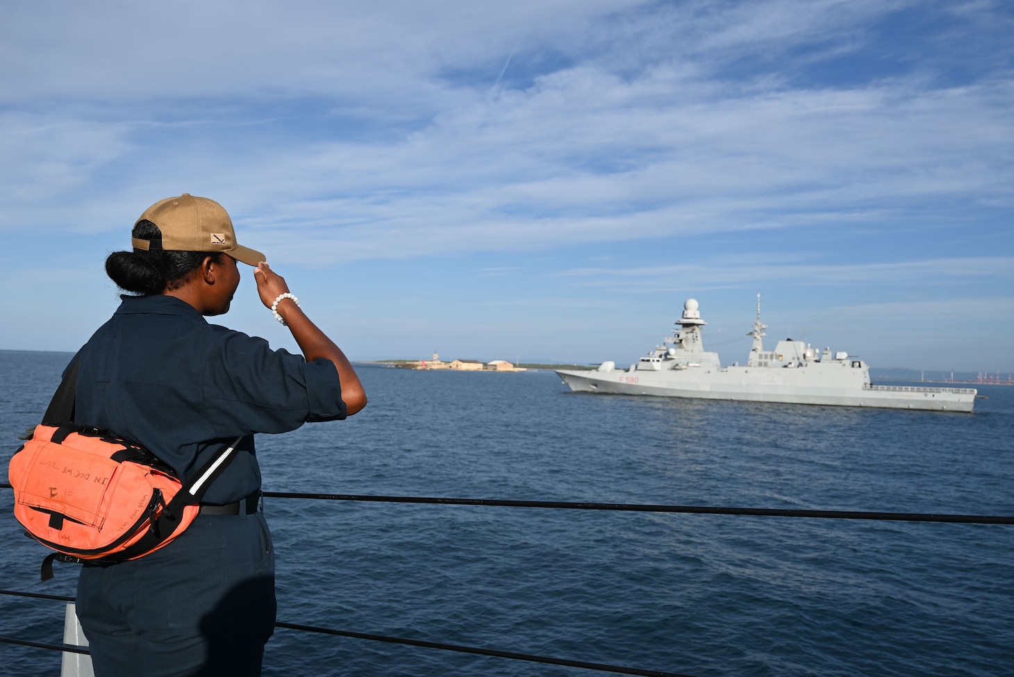 Hospital Corpsman 3rd Class Tia Jeter exchanges honors with the Carlo Bergamini-class frigate ITS Carlo Bergamini (F 590) of the Italian Navy during a sea and anchor evolution into Taranto, Italy.