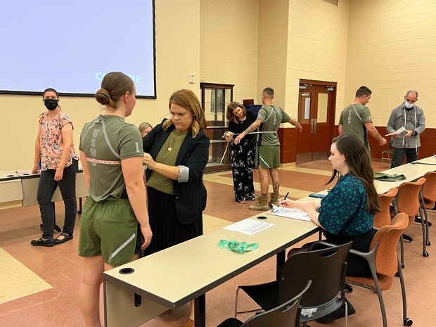 Navy Clothing and Textile Research Facility clothing designer Katie Verrico measures a female Marine during Marine Corps Systems Command’s latest limited user evaluation of the redesigned physical training uniform prototype at Marine Corps University, Sept. 13, 2022.