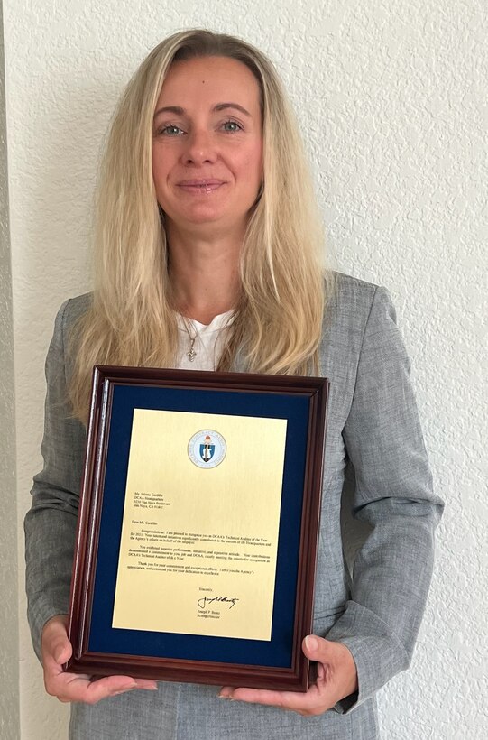 woman poses with award