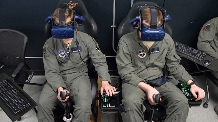 U.S. Air Force Second Lt. Charles Keller and Airman First Class Tyler Haselden, Pilot Training Next students, train on a virtual reality flight simulator at the Armed Forces Reserve Center in Austin, Texas, June 21, 2018. PTN is an Air Education and Training Command initiative to explore and potentially prototype a training environment that integrates various technologies to produce pilots in an accelerated, cost-efficient, learning-focused manner. The six-month program leans on a variety of technologies, to include virtual and augmented reality, advanced biometrics, artificial intelligence and data analytics. (U.S. Air Force photo by Sean M. Worrell)