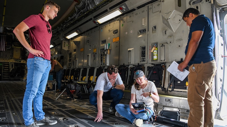 A team from the Air Force Institute of Technology, Air Force Research Lab, and Department of the Air Force/Massachusetts Institute of Technology Artificial Intelligence Accelerator prepare a Mag in a Box, a navigation system for GPS denied environments, for testing on a 445th Airlift Wing C-17 Globemaster III Aug 6, 2021. A team from the Air Force Institute of Technology, Air Force Research Lab, and Department of the Air Force/Massachusetts Institute of Technology Artificial Intelligence Accelerator are working on magnetic-navigation research and brought a stand-alone sensor to test on the C-17 help characterize the platform.