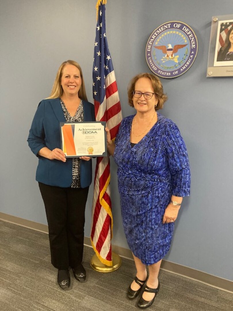 two women hold a certificate