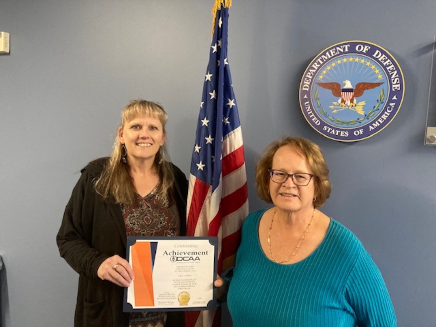 two women hold a certificate