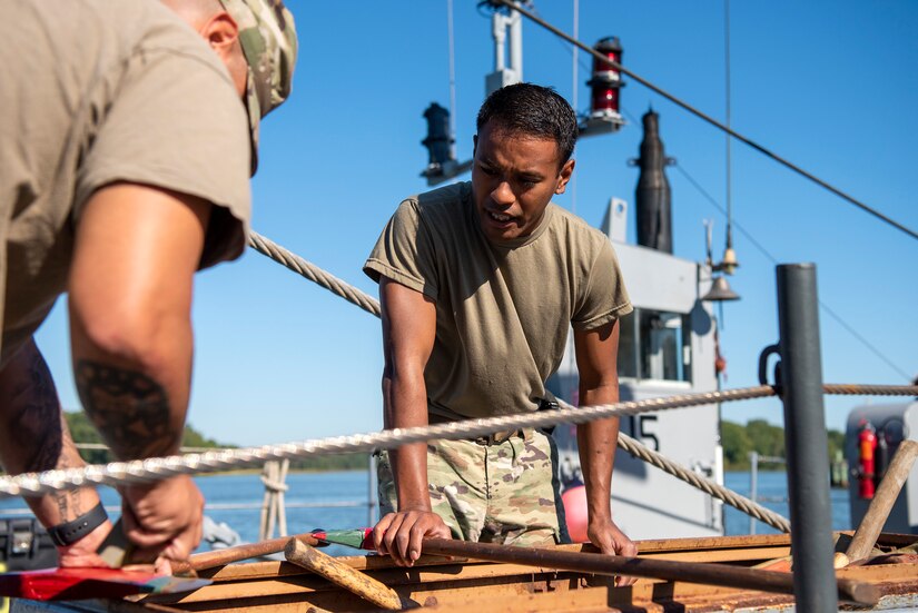 U.S. Army Sgt. Judah Sibetang (right) and Sgt. Willis Lopez-Ocasio, 331st Transportation Company, 11th Transportation Battalion, 7th Transportation Brigade (Expeditionary), coxswain, performs maintenance on shipboard equipment at Joint Base Langley-Eustis, Virginia, September 21, 2022.