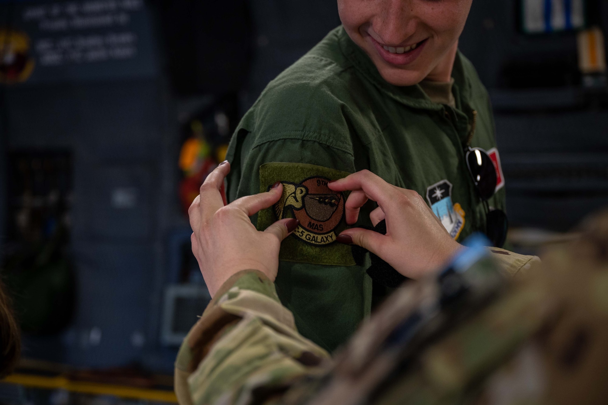 Staff Sgt. Amelia Bradfield, 9th Airlift Squadron loadmaster, puts a patch on a United States Air Force Academy cadet during an outreach event at Peterson Space Force Base, Colorado, Sept. 30, 2022. During the event, the aircrew was able to brief over 175 cadets on science, technology, engineering and mathematics career field opportunities in the U.S. Air Force. (U.S. Air Force photo by Senior Airman Faith Barron)