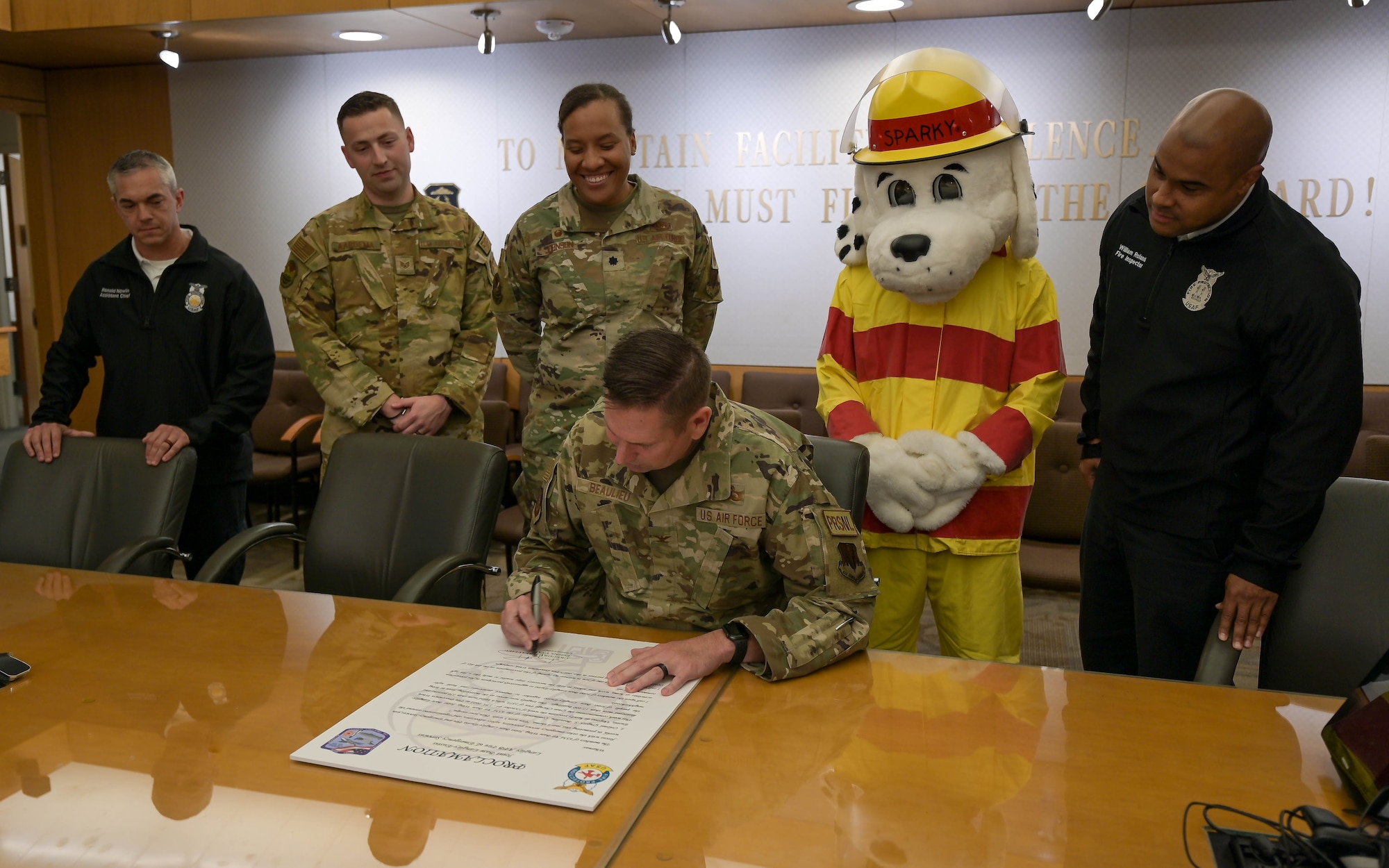 Col. signs a paper.