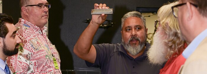 Eric Garcia, shows visitors a steel bar melted by an 11 kilowatt laser during a tour of the base, Nov. 12, 2021.