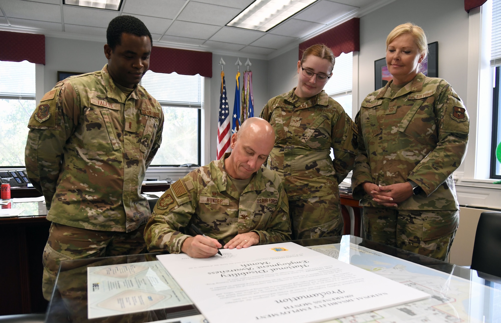 U.S. Air Force Col. William Hunter, 81st Training Wing commander, signs the National Disability Employment Awareness Month proclamation inside the 81st TRW headquarters building at Keesler Air Force Base, Mississippi, Oct. 4, 2022. NDEAM celebrates the contributions of America's workers with disabilities past and present and showcases supportive, inclusive employment policies and practices. (U.S. Air Force photo by Kemberly Groue)