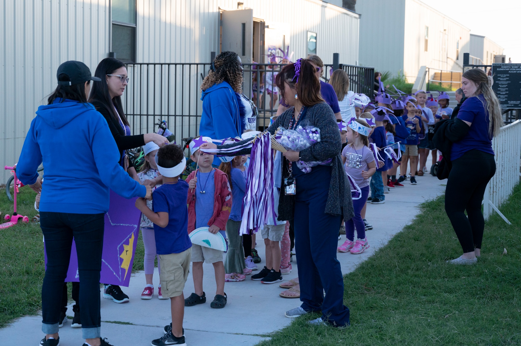 Staﬀ from the Roberto Bobby Barrera (RBB) Elementary School hand out streamers to students as they prepare to walk the “Purple Parade” held at Laughlin Air Force Base, Texas, Sept. 29, 2022. The “Purple Parade” was held in celebration of RBB Elementary School receiving the Purple Star Award, recognizing the support and commitment the school provides to meeting the unique needs of military-connected students and their families. (U.S. Air Force photo by Airman 1st Class Kailee Reynolds)