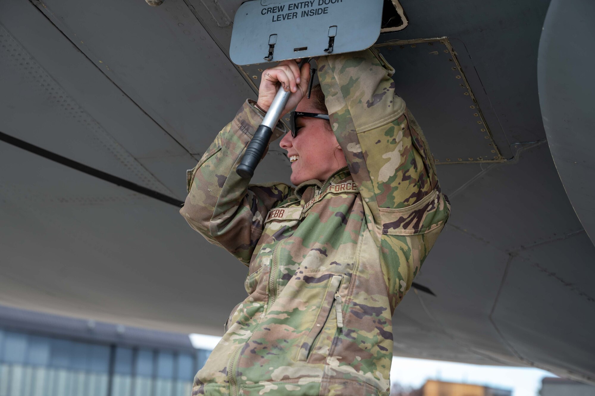 Airman 1st Class Avery Webb, 436th Aircraft Maintenance Squadron crew chief, hand cranks a Dover Air Force Base C-5M Super Galaxy crew door open at Peterson Space Force Base, Colorado, Oct. 1, 2022. During their visit to Peterson SFB, the crew members were able to brief United States Air Force Academy cadets and family members on the Dover AFB mission as well as active duty and reservist career opportunities in the U.S. Air Force. (U.S. Air Force photo by Senior Airman Faith Barron)