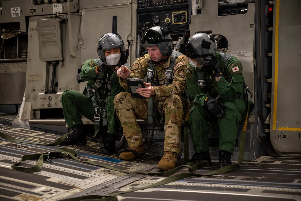 U.S. Air Force Senior Airman Andrew Girard, 535th Airlift Squadron loadmaster, briefs two members of the Japan Air Self-Defense Force (Koku-Jieitai) during a training exercise around the Hawaiian Islands, Sept. 27, 2022. This is the first bilateral exercise between the squadrons, increasing interoperability and familiarizing both forces on the capabilities of the Kawasaki C-2 and C-17 Globemaster III. (U.S. Air Force photo by Senior Airman Makensie Cooper)
