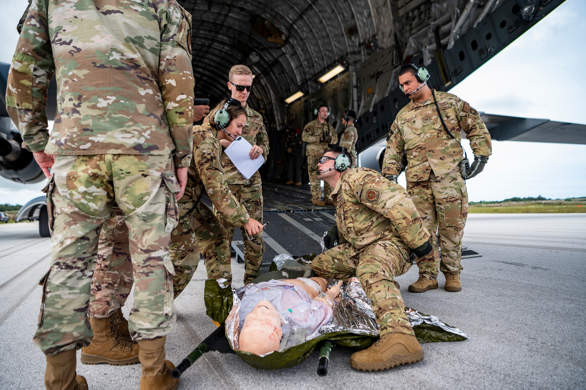 People practice medical procedures near a plane