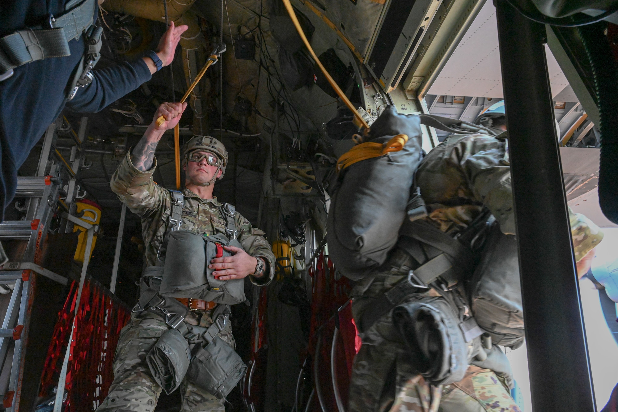 Paratroopers jump off a plane.