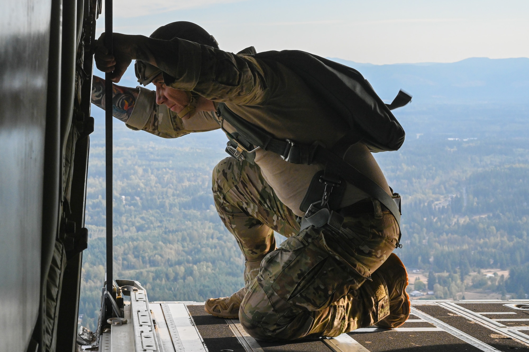 Paratrooper checks the views on a flying plane.