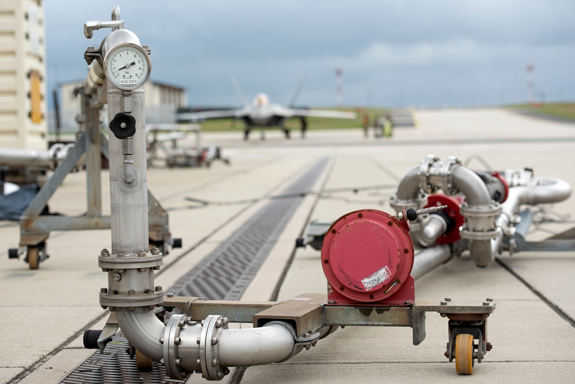 A close up of fuel equipment at Spangdahlem Air Base in the foreground, Germany with an F-22 out of focus in the background.