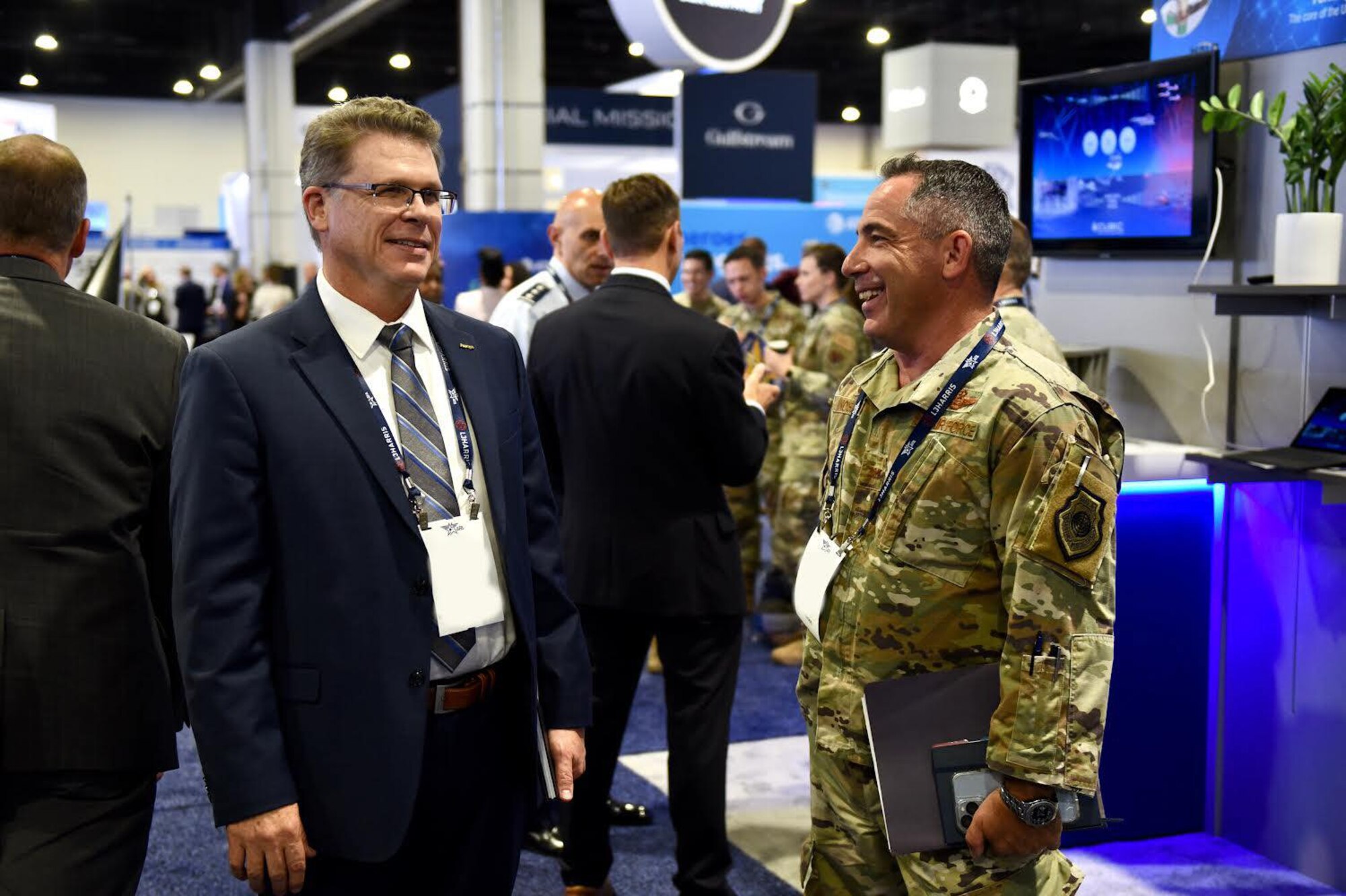 U.S. Air Force Col. Josh Koslov, 350th Spectrum Warfare commander, meets with U.S. Air Force retired Brig. Gen. Steve Bleymaier, Ansys chief technology officer aerospace and defense, discuss the prioritization of Electromagnetic Warfare by the Air Force and industry at the Air, Space & Cyber Conference in Washington D.C., Sept. 19, 2022. The 350th SWW attended the conference to not only moderate an Electromagnetic Warfare (EW) panel, but to meet with partners across the DoD and industry to cultivate potential relationships to further the development of lethal EW capabilities to support the warfighter. (U.S. Air Force photo by 1st Lt Benjamin Aronson) (This photo has been altered for security purposes by blurring out identification badges.)