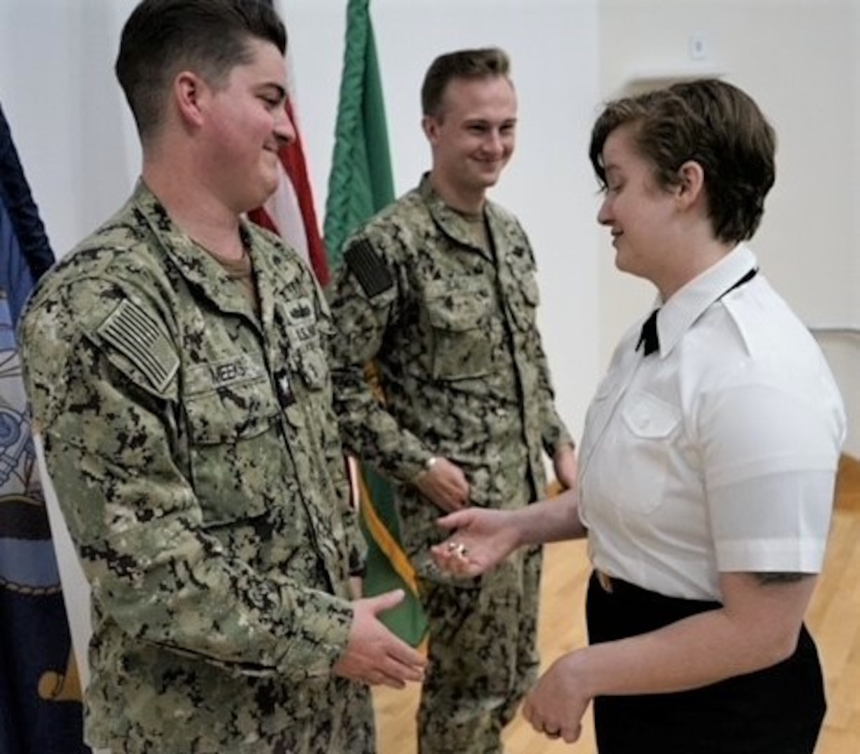 a passing of tradition...As part of her commissioning process going

from hospital corpsman second class to ensign, Michaela Nicole Emert

designates Hospital Corpsman 3rd Class Jonathon Meeks as recipient of her

petty officer insignia to continue to advance in rate and responsibility as