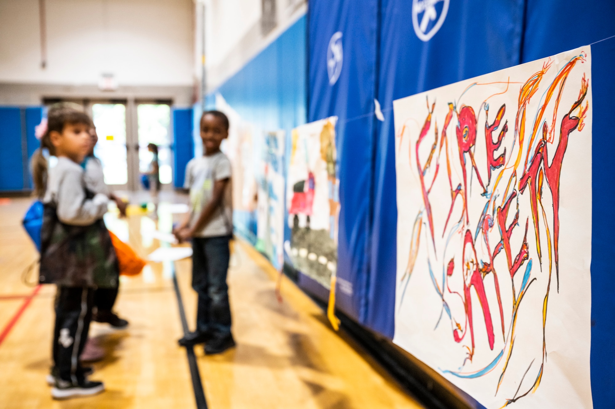 Children look at artwork.
