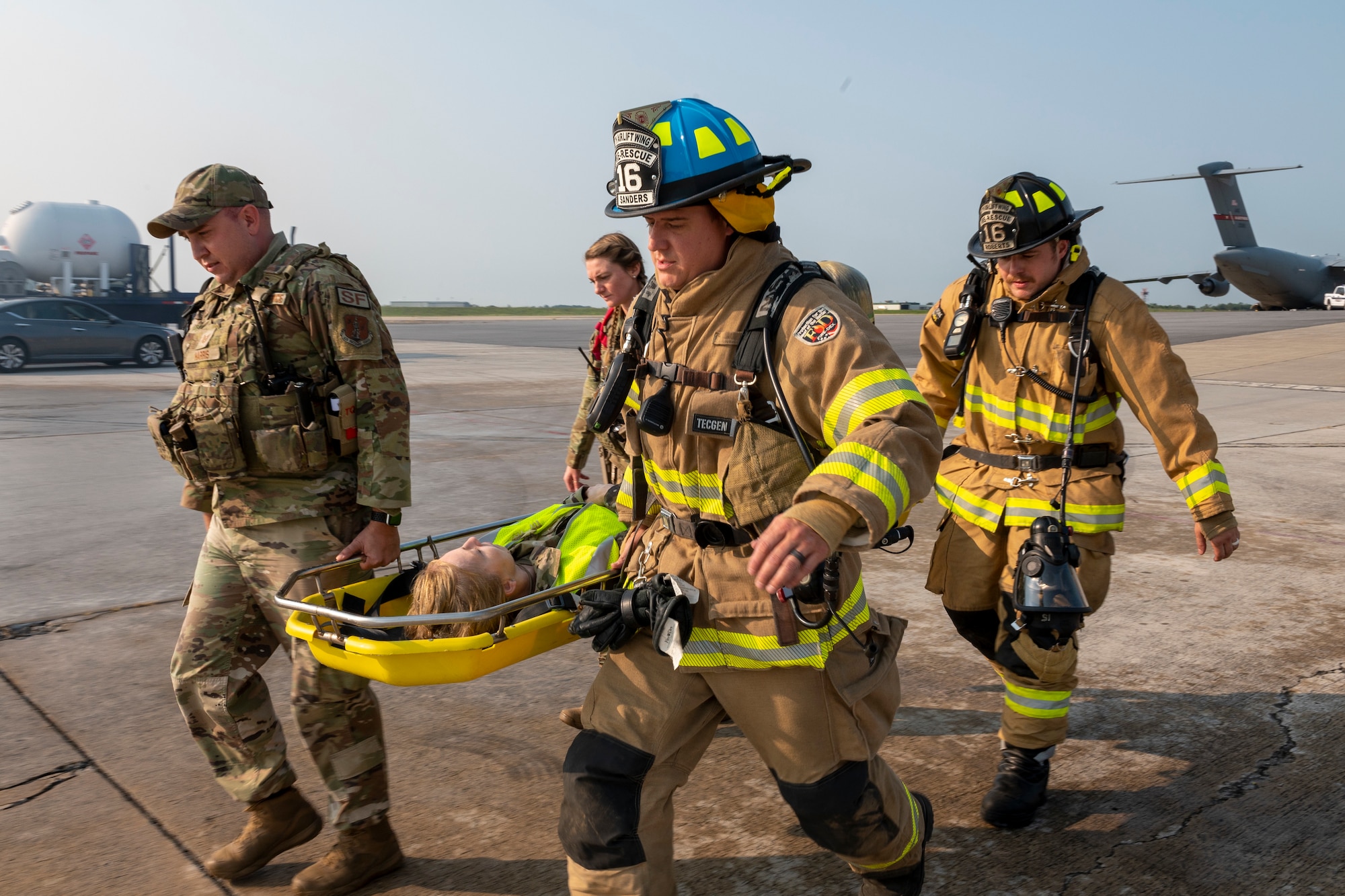 U.S. Air Force Staff Sgt. Geoffrey Harris and Staff Sgt. Kayla Sine, 167th Security Forces Squadron, and Staff Sgt. Timothy Sanders and Staff Sgt Cory Roberts, 167th Civil Engineering Squadron fire fighters, carry Senior Master Sgt. Angela Layton who is simulating a victim of an aircraft mishap during an emergency response exercise at the 167th Airlift Wing, Shepherd Field, Martinsburg, West Virginia, Sept. 16, 2022.
