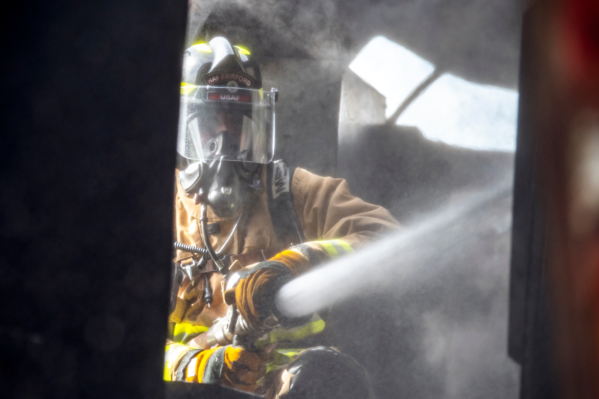 A firefighter from the 422d Fire Emergency Services extinguishes an aircraft fire during a live-fire training exercise at RAF Fairford, England, Oct. 3, 2022. Firefighters from the 422d FES are required to complete live-fire training bi-annually to test their overall readiness and ability to properly extinguish an aircraft fire. (U.S. Air Force photo by Staff Sgt. Eugene Oliver)