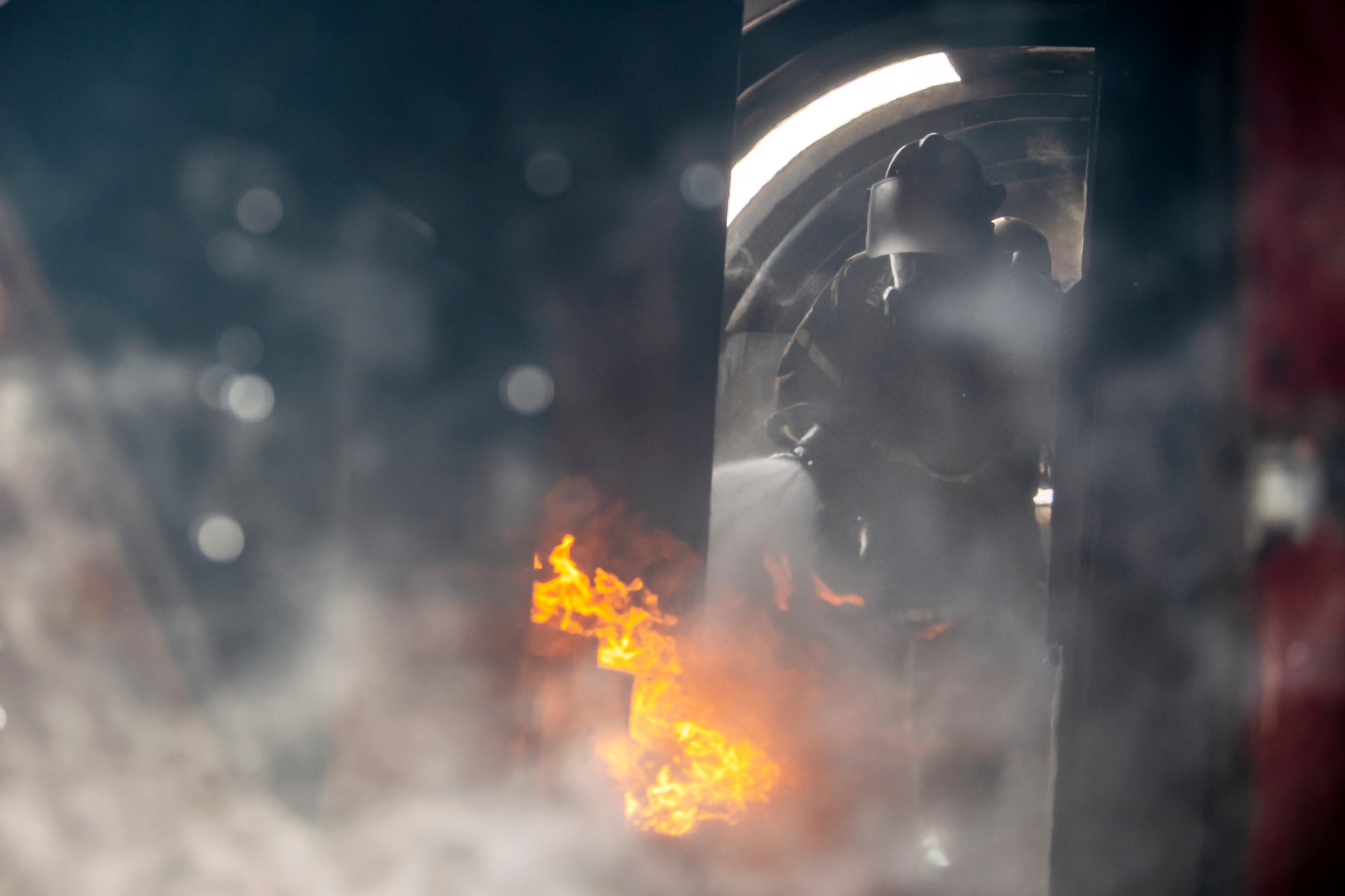 A firefighter from the 422d Fire Emergency Services extinguishes an aircraft fire during a live-fire training exercise at RAF Fairford, England, Oct. 3, 2022. Firefighters from the 422d FES are required to complete live-fire training bi-annually to test their overall readiness and ability to properly extinguish an aircraft fire. (U.S. Air Force photo by Staff Sgt. Eugene Oliver)