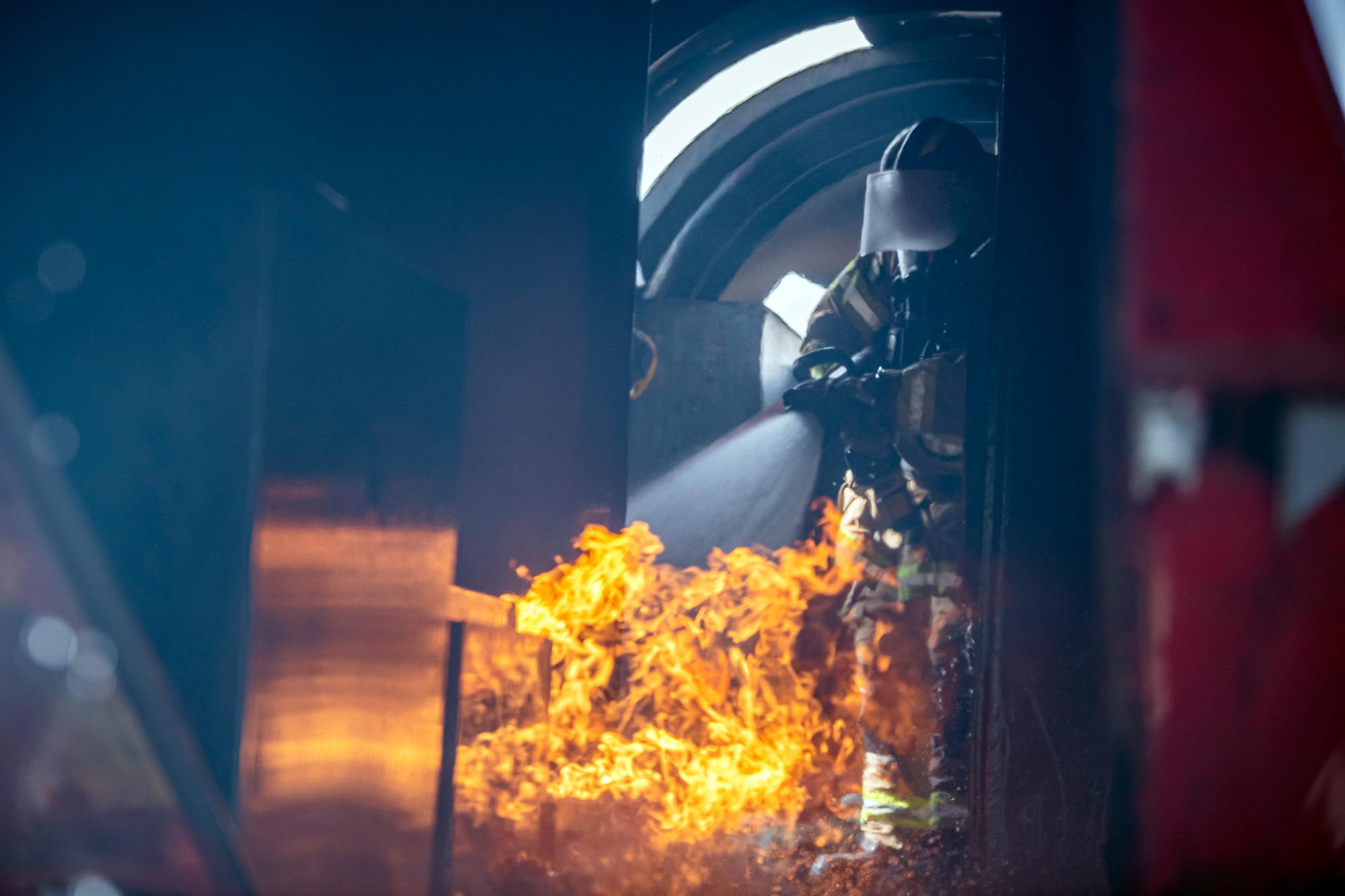 A firefighter from the 422d Fire Emergency Services extinguishes an aircraft fire during a live-fire training exercise at RAF Fairford, England, Oct. 3, 2022. Firefighters from the 422d FES are required to complete live-fire training bi-annually to test their overall readiness and ability to properly extinguish an aircraft fire. (U.S. Air Force photo by Staff Sgt. Eugene Oliver)