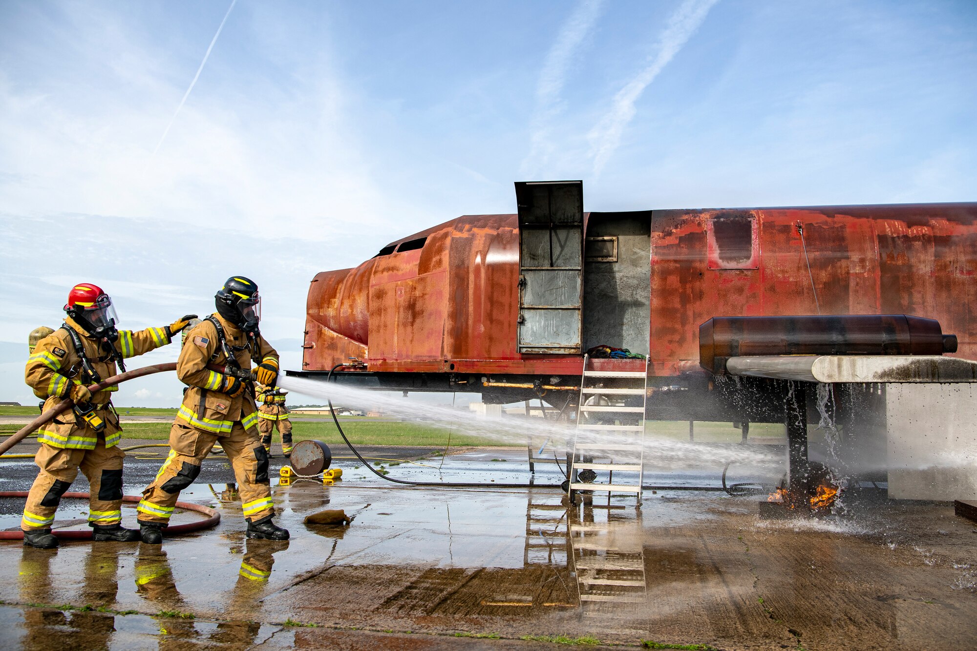 Firefighters from the 422d Fire Emergency Services extinguish an aircraft fire during a live-fire training exercise at RAF Fairford, England, Oct. 3, 2022. Firefighters from the 422d FES are required to complete live-fire training bi-annually to test their overall readiness and ability to properly extinguish an aircraft fire. (U.S. Air Force photo by Staff Sgt. Eugene Oliver)