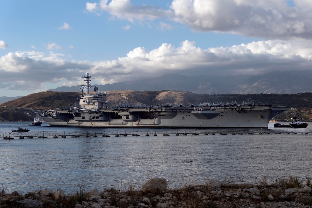 The Nimitz-class aircraft carrier USS George H.W. Bush (CVN 77),  in Souda Bay, with mountains in the background.