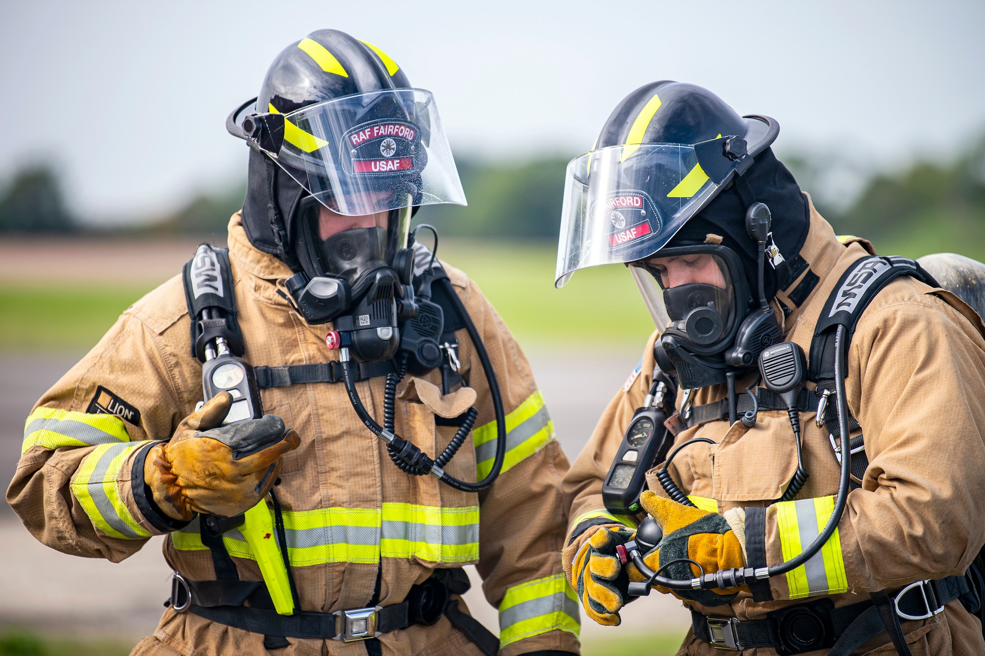 Firefighters from the 422d Fire Emergency Services, check their oxygen levels during a live-fire training exercise at RAF Fairford, England, Oct. 3, 2022. Firefighters from the 422d FES, are required to complete live-fire training bi-annually to test thief overall readiness and ability to properly extinguish an aircraft fire. (U.S. Air Force photo by Staff Sgt. Eugene Oliver)
