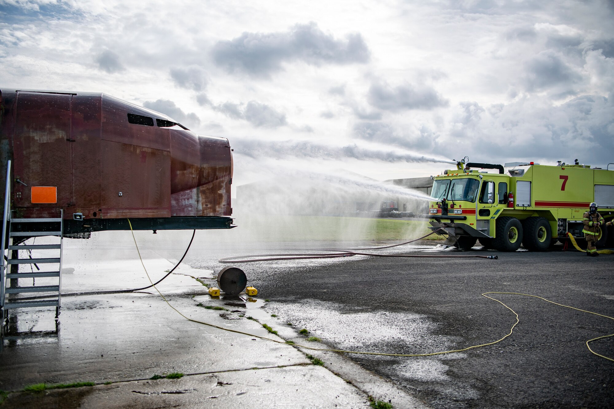 A firetruck from the 422d Fire Emergency Services extinguishes an aircraft fire during  a live-fire training exercise at RAF Fairford, England, Oct. 3, 2022. Firefighters from the 422d FES, are required to complete live-fire training bi-annualy to test thief overall readiness and ability to properly extinguish an aircraft fire. (U.S. Air Force photo by Staff Sgt. Eugene Oliver)