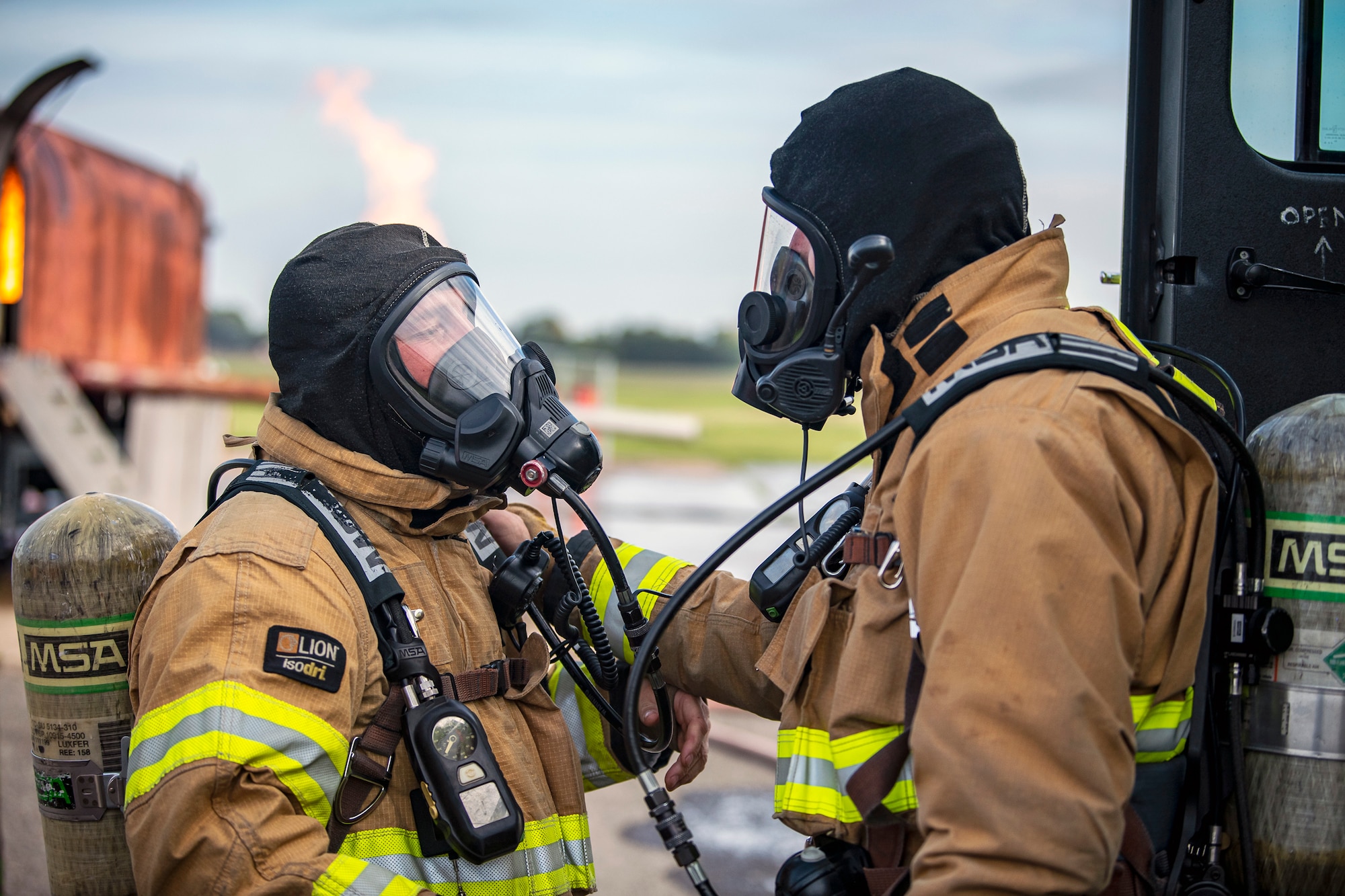 Firefighters from the 422d Fire Emergency Services perform buddy checks prior to a live-fire training exercise at RAF Fairford, England, Oct. 3, 2022. Firefighters from the 422d FES, are required to complete live-fire training bi-annualy to test thief overall readiness and ability to properly extinguish an aircraft fire. (U.S. Air Force photo by Staff Sgt. Eugene Oliver)