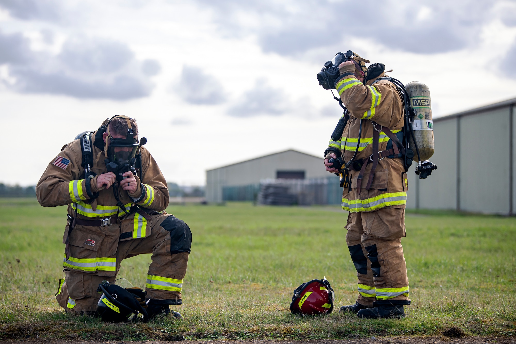 Firefighters from the 422d Fire Emergency Services take off their equipment following a live-fire training exercise at RAF Fairford, England, Oct. 3, 2022. Firefighters from the 422d FES, are required to complete live-fire training bi-annualy to test thief overall readiness and ability to properly extinguish an aircraft fire. (U.S. Air Force photo by Staff Sgt. Eugene Oliver)