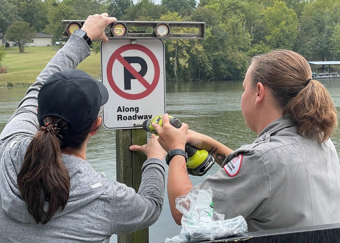 During National Public Lands Day, Park Rangers Danielle Knowles and volunteer Kim Johnson mount a new “no parking” sign at a Stark Knob Boat Ramp parking lot on Old Hickory Lake in Hendersonville, Tennessee.