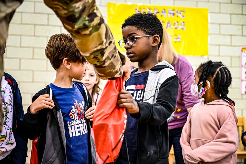 U.S. Army Command Sgt. Maj. James Van Zlike and U.S. Army Col. Mitchell Wisniewski, Army Support Activity Fort Dix command team, hand out bags to elementary school children in support of Red Ribbon Week awareness on Oct. 6, 2022, at Joint Base McGuire-Dix-Lakehurst, N.J. Red Ribbon Week is observed and celebrated the last week of October, it is the largest and longest running drug awareness program nationwide.