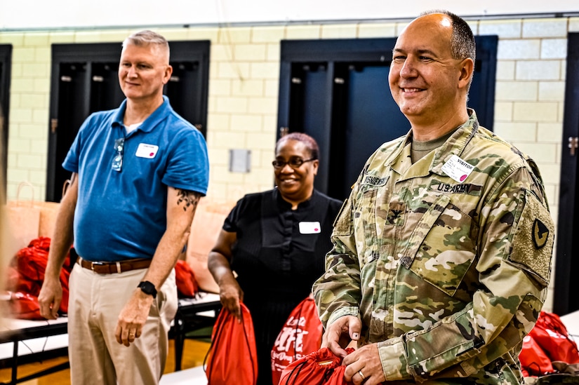 U.S. Army Command Sgt. Maj. James Van Zlike and U.S. Army Col. Mitchell Wisniewski, Army Support Activity Fort Dix command team, hand out bags to elementary school children in support of Red Ribbon Week awareness on Oct. 6, 2022, at Joint Base McGuire-Dix-Lakehurst, N.J. Red Ribbon Week is observed and celebrated the last week of October, it is the largest and longest running drug awareness program nationwide.