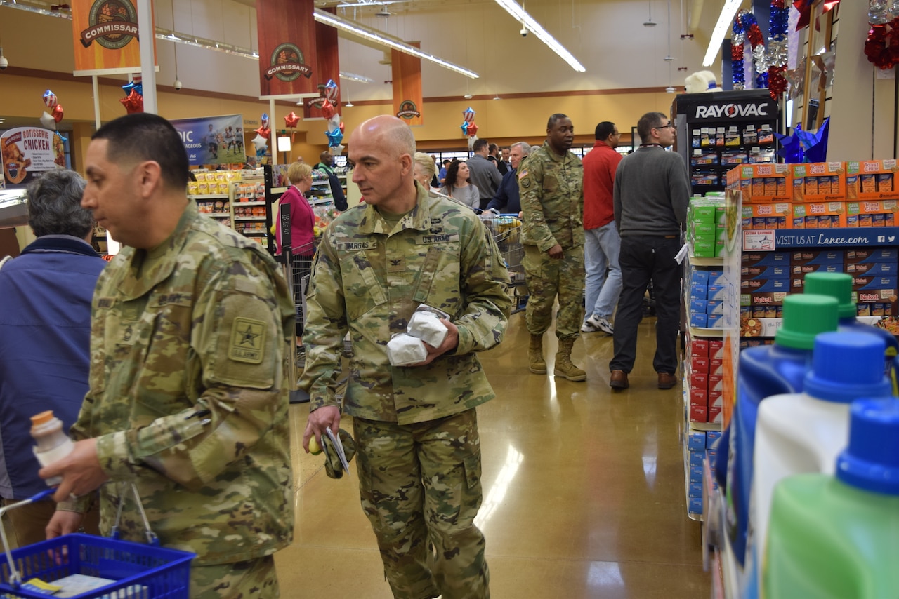 Uniformed soldiers walk through a grocery store.