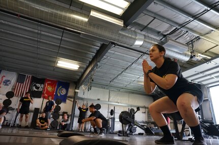 gt. Katie Mazos-Vega, a public affairs specialist with the 134th Public Affairs Detachment, and Pvt. Mark Salta, an infantryman with Bravo Company, 1st Battalion, 297th Infantry Regt., complete 40 squats as part of a baseline physical fitness test for the annual wellness camp held at Camp Carroll, Joint Base Elmendorf-Richardson, Alaska, Aug. 29, 2022. The annual wellness camp focuses on the Army’s Holistic Health and Fitness concept and prepares Soldiers to maintain an overall healthy lifestyle. (Alaska National Guard photo by Sgt. Kekoa Macloves)