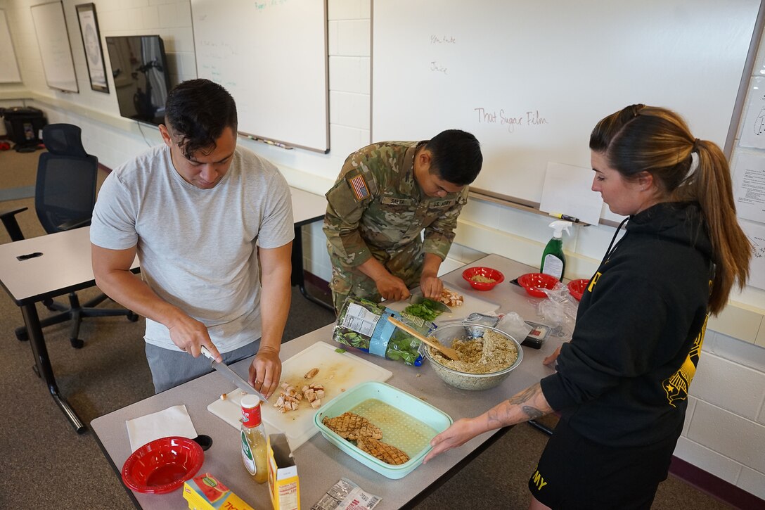 Sgt. Kekoa Macloves, an instructor for the wellness camp from 1st Battalion, 297th Infantry Regt. and Pvt. Mark Salta, an infantryman with Bravo Company, 1st Battalion, 297th Infantry Regt. prepare protein bowls as part of a nutrition class taught by Sgt. 1st Class Melissa Ferguson, an officer candidate school instructor with 207th Multi-Functional Training Regt. during the annual wellness camp held at Camp Carroll, Joint Base Elmendorf-Richardson, Alaska, Aug. 30, 2022. The annual wellness camp focused on the Army’s Holistic Health and Fitness concept and prepares Soldiers to maintain an overall healthy lifestyle. (Alaska National Guard photo by Staff Sgt. Katie Mazos-Vega)
