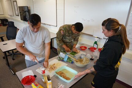 Sgt. Kekoa Macloves, an instructor for the wellness camp from 1st Battalion, 297th Infantry Regt. and Pvt. Mark Salta, an infantryman with Bravo Company, 1st Battalion, 297th Infantry Regt. prepare protein bowls as part of a nutrition class taught by Sgt. 1st Class Melissa Ferguson, an officer candidate school instructor with 207th Multi-Functional Training Regt. during the annual wellness camp held at Camp Carroll, Joint Base Elmendorf-Richardson, Alaska, Aug. 30, 2022. The annual wellness camp focused on the Army’s Holistic Health and Fitness concept and prepares Soldiers to maintain an overall healthy lifestyle. (Alaska National Guard photo by Staff Sgt. Katie Mazos-Vega)
