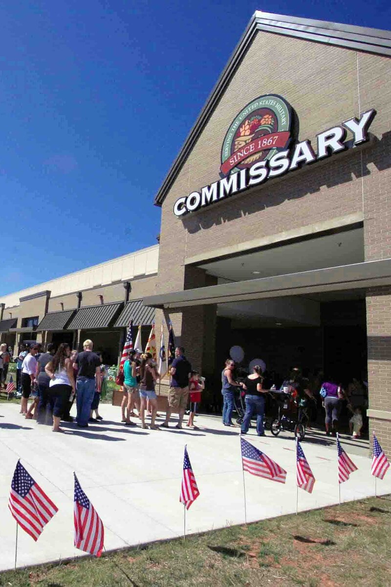 People, some in uniform, gather outside a building.