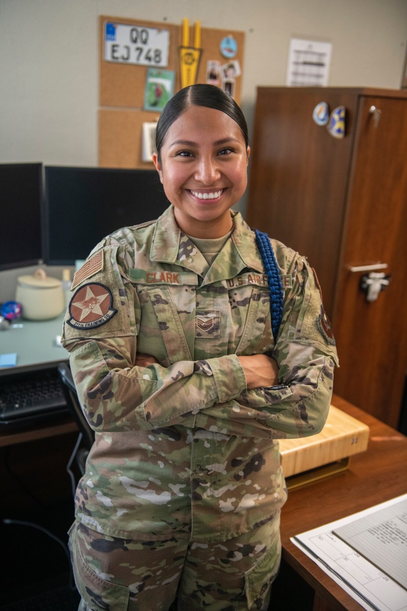 U.S. Air Force Staff Sgt. Karely Clark, 311th Training Squadron military training leader, stands at her desk at Presidio of Monterey, Calif., Oct. 5, 2022. Clark takes inspiration from Puerto Rican rapper Benito Antonio Martinez Ocasio or as he is most known, Bad Bunny, and his message of challenging negative gender roles in Hispanic culture. (DoD photo by Leo Carrillo)